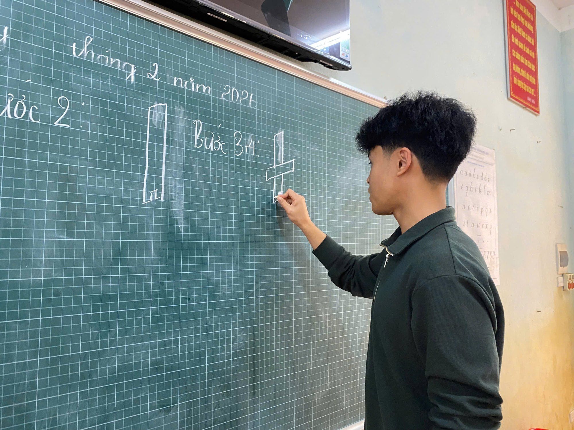 Bao writing on a classroom chalkboard.