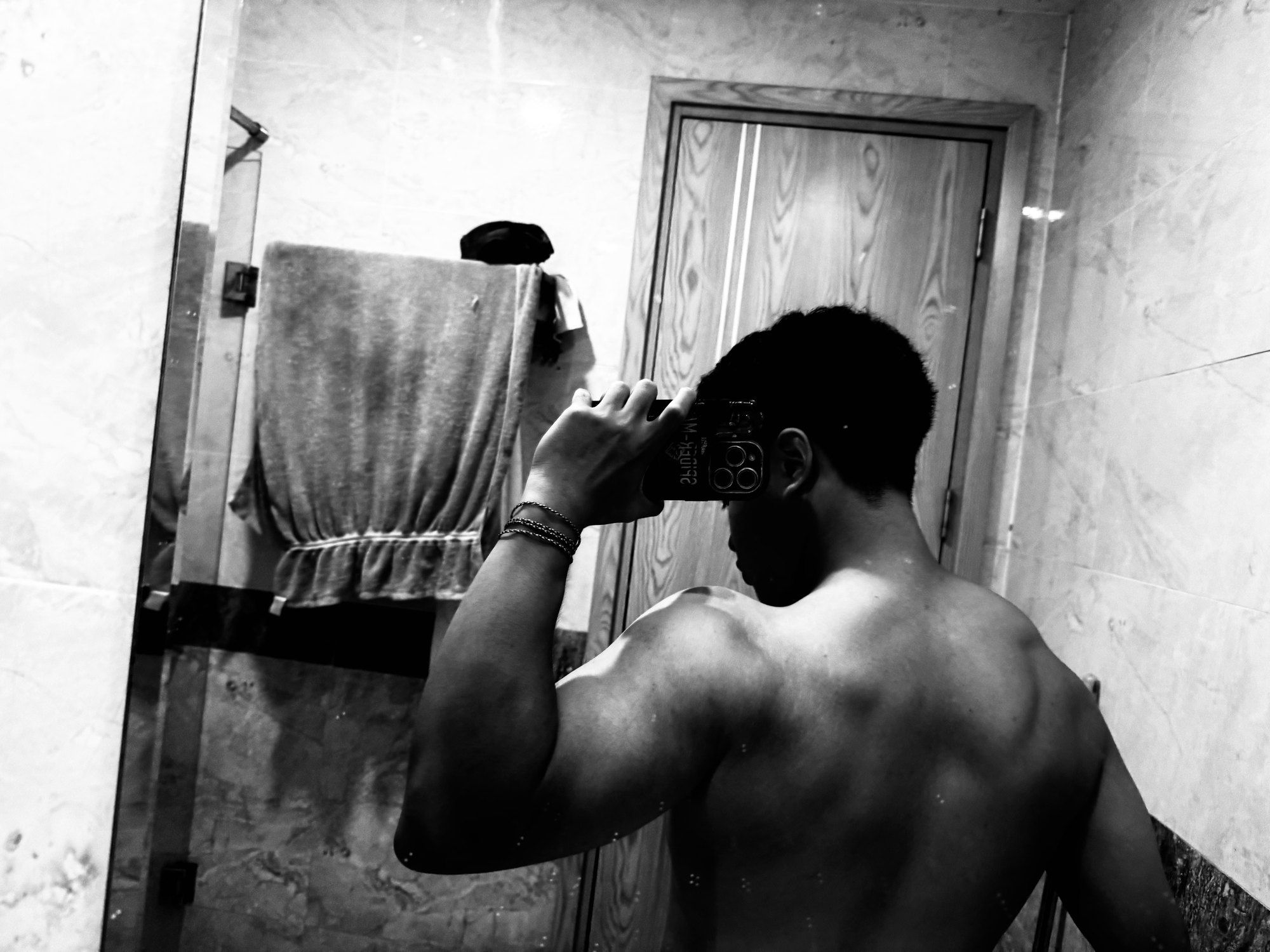 Black-and-white mirror photo of Bao training his back and shoulders.