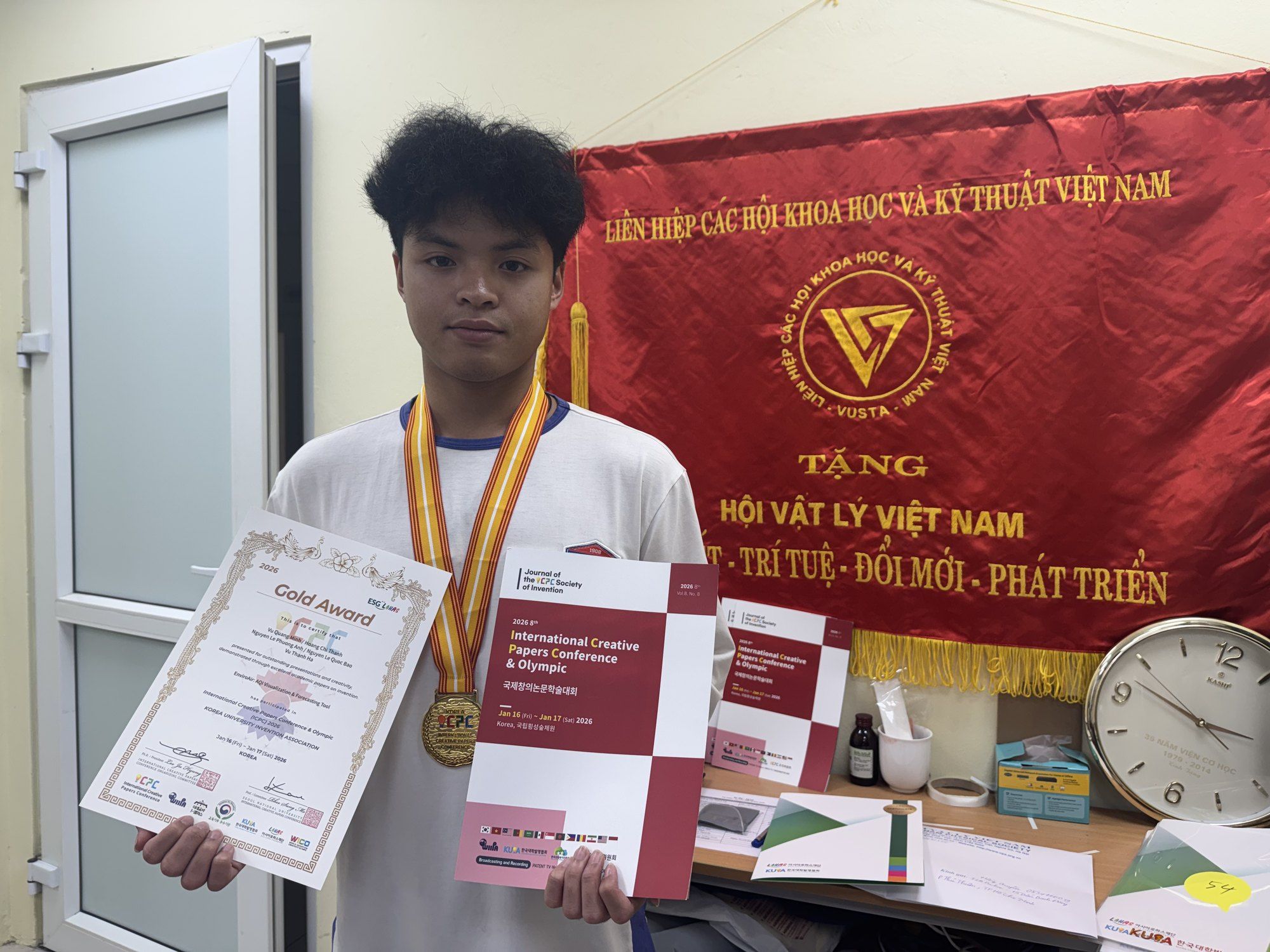 Bao holding the ICPC 2026 Gold Award certificate and wearing a medal.