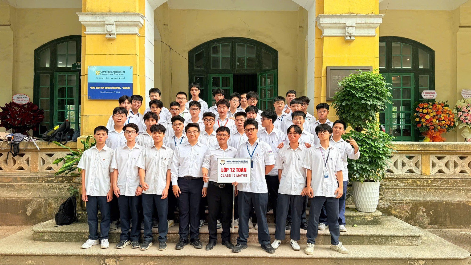 A Chu Van An class group photo in front of the school building.