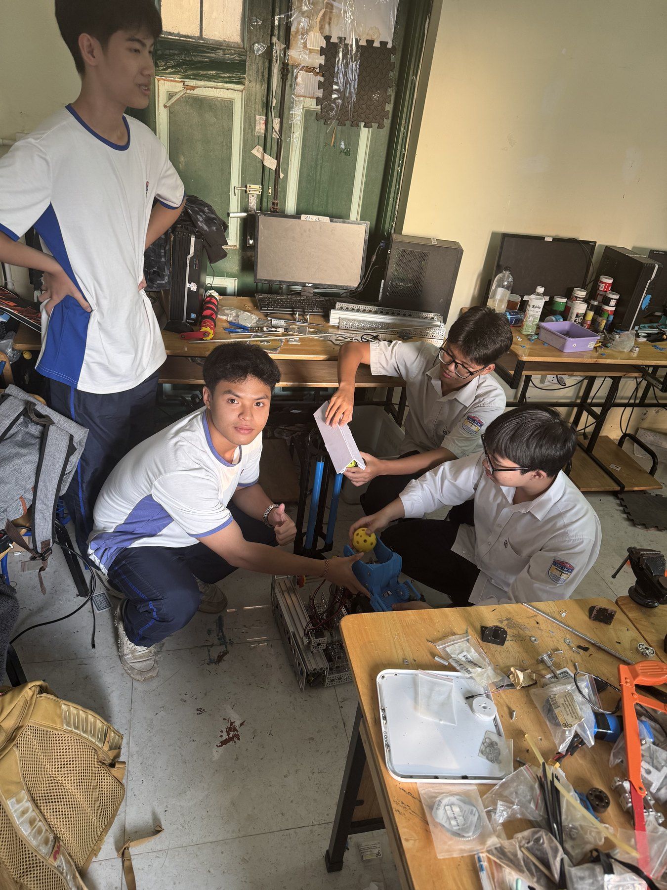 Students assembling a prototype on the floor of a lab.