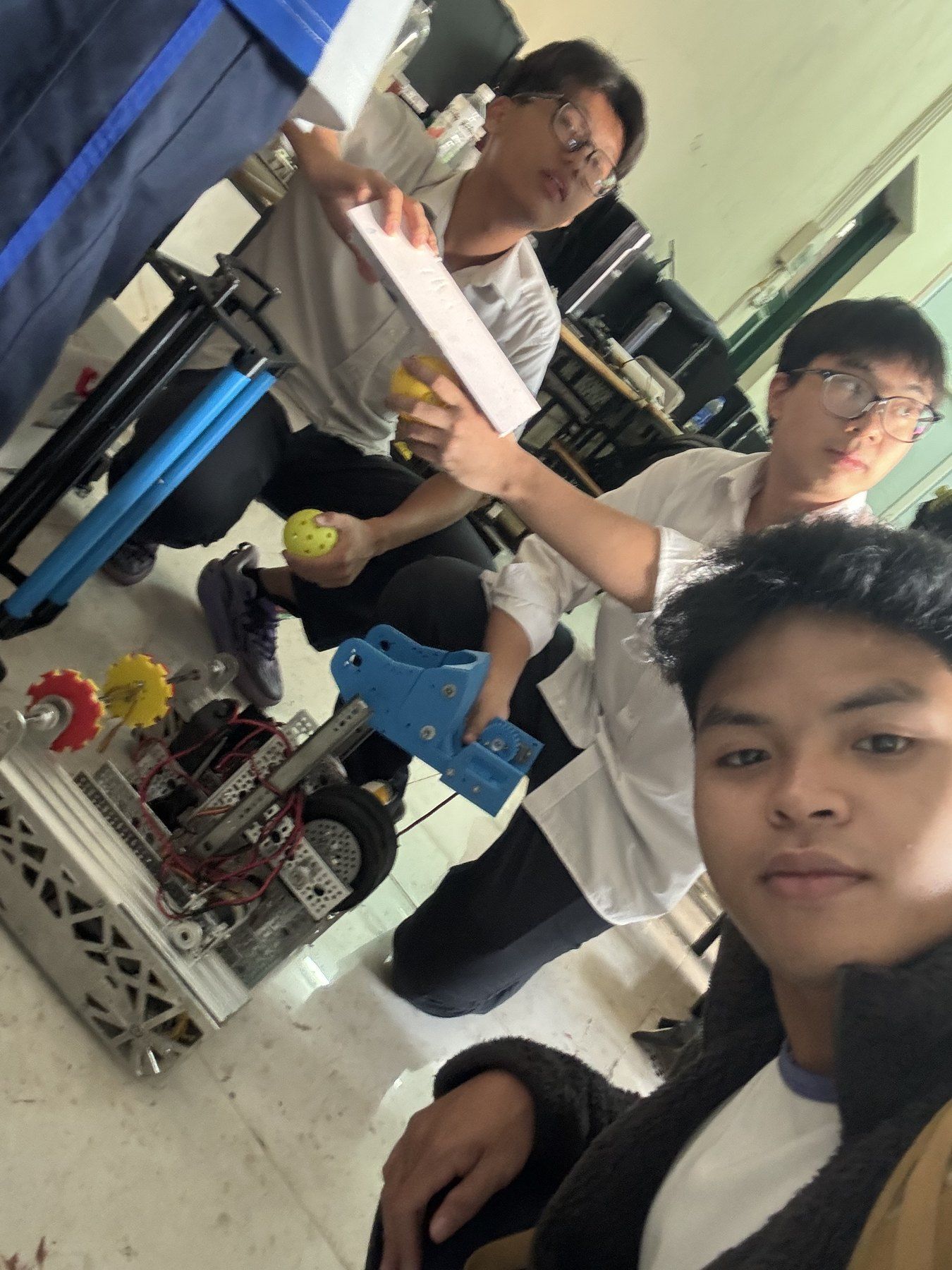 A selfie with teammates beside a prototype.