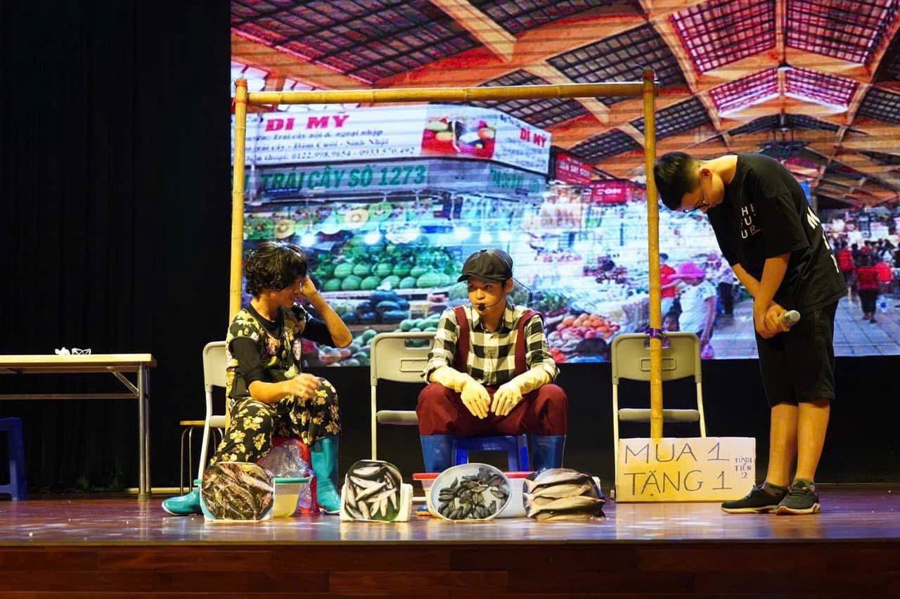 A stage performance with a market-scene backdrop.