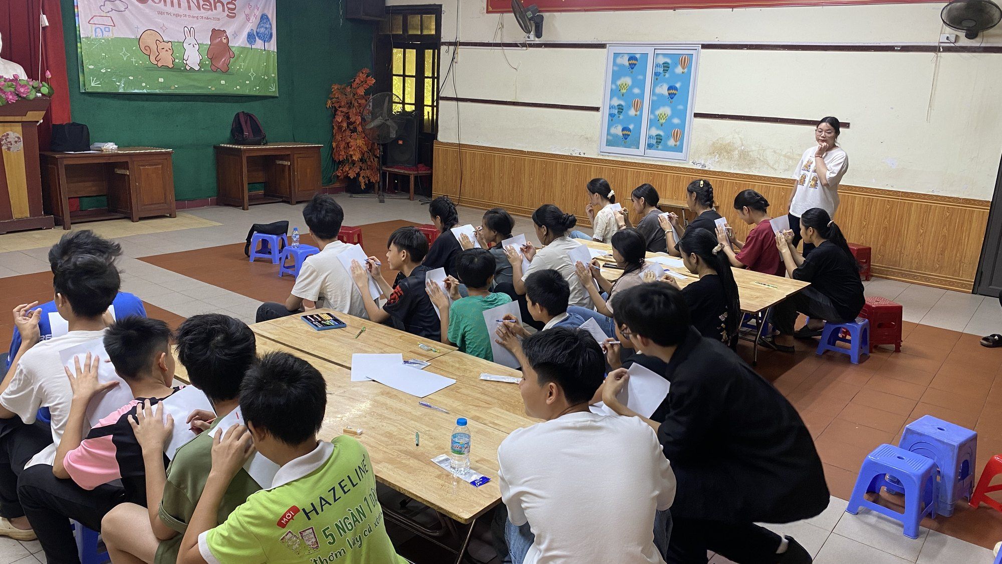 Volunteers teaching a lesson to children seated at long tables at SOS Children’s Village Việt Trì.