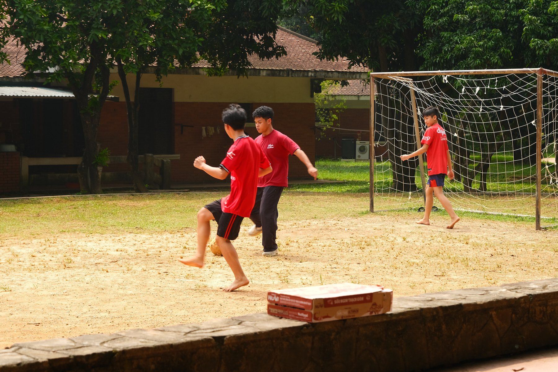 Playing football with children on a sandy pitch at SOS Children’s Village Việt Trì.