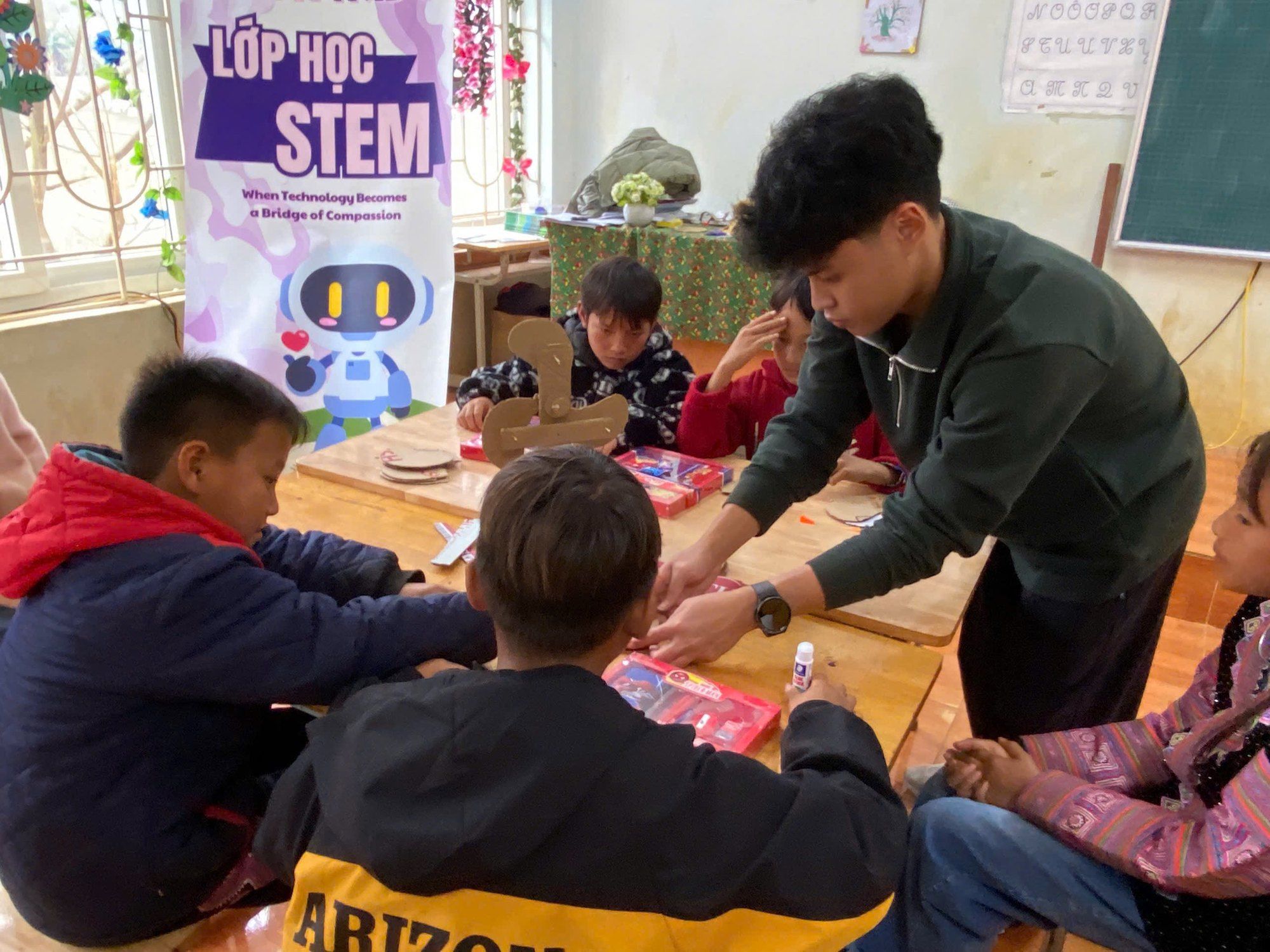 Bao helping children with a hands-on activity in a STEM class.